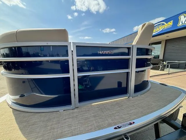 Slide: The Image of 2024 Harris Cruiser 230 CWDH pontoon boat with blue exterior and beige seating. - 6