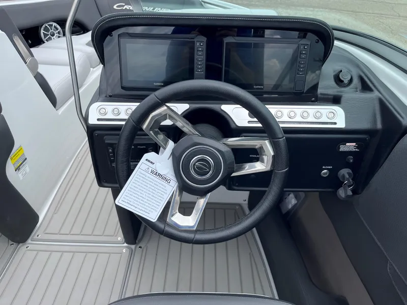 Slide: The Image of 2025 Crownline 240 SS boat dashboard with steering wheel and dual display screens. - 8