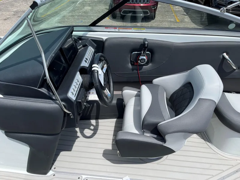 Slide: The Image of 2025 Crownline 220 SS boat cockpit with modern steering wheel and comfortable seating. - 7