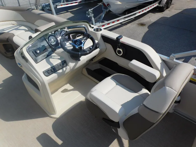 Slide: The Image of 2024 Avalon LSZ Quad Lounger boat cockpit with steering wheel and captain's chair. - 13