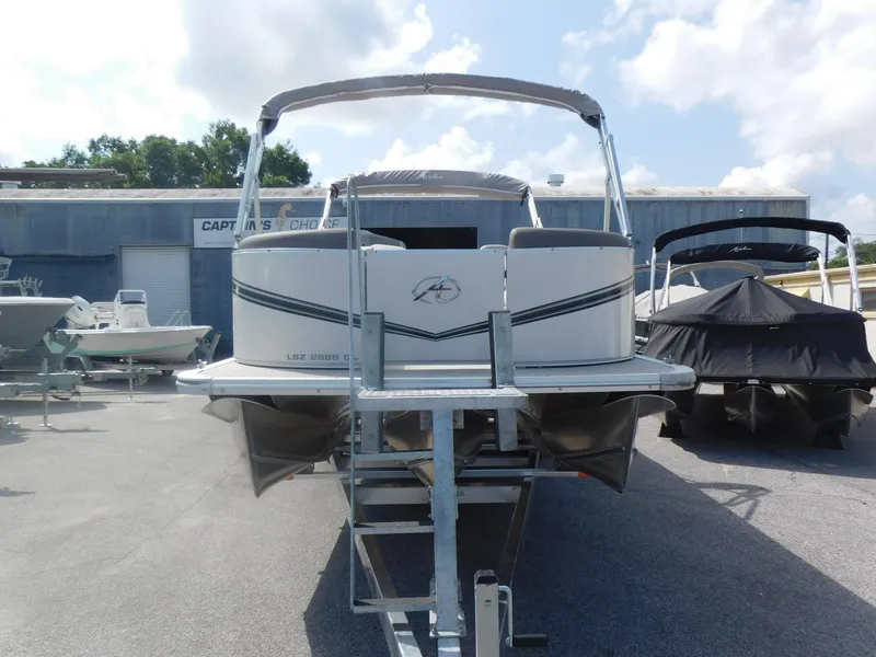 Slide: The Image of 2024 Avalon LSZ Quad Lounger pontoon boat on trailer, front view. - 2
