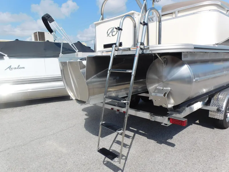Slide: The Image of 2024 Avalon LSZ Quad Lounger pontoon boat with rear ladder and trailer. - 6