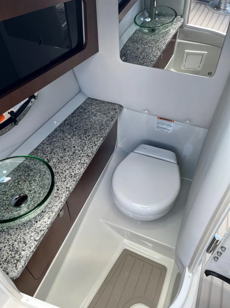 Slide: The Image of Modern bathroom in 2025 Crownline 290 SS boat with granite countertop and glass sink. - 10