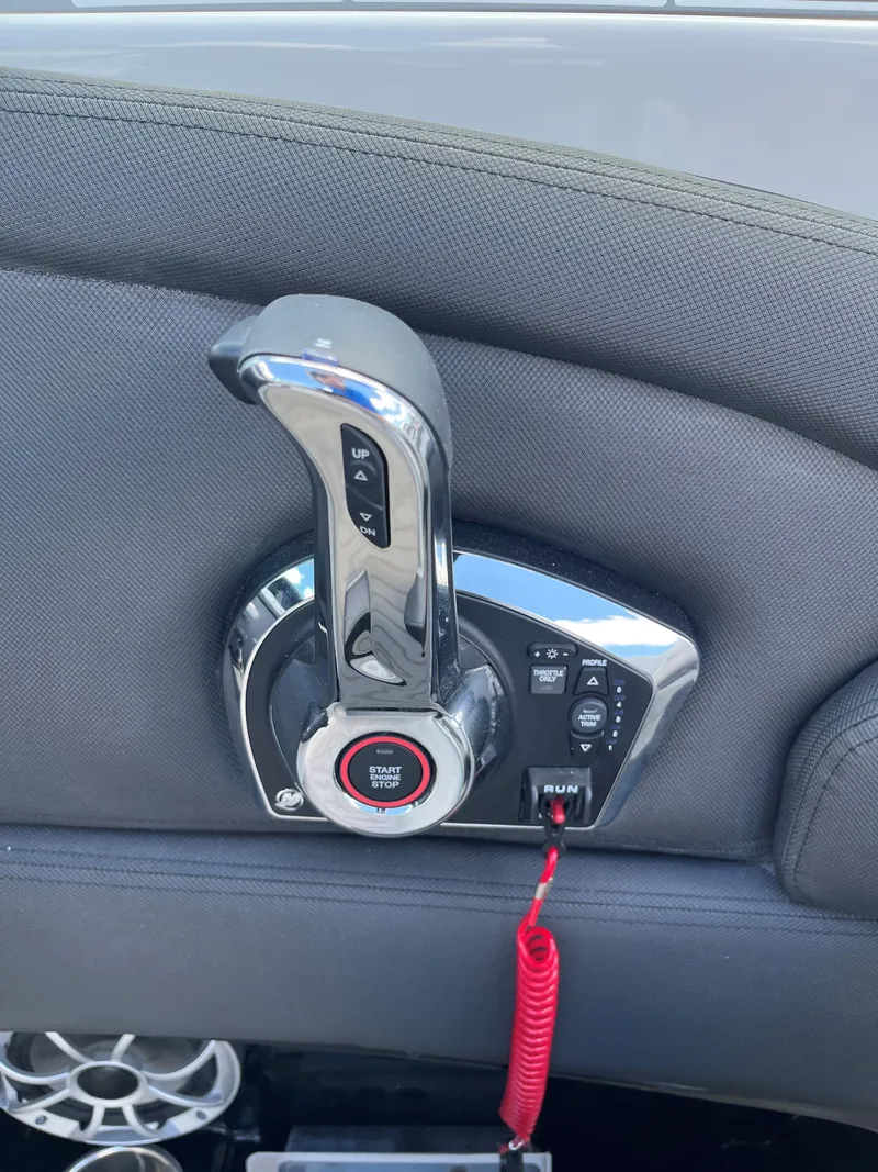 Slide: The Image of 2025 Crownline 290 SS boat throttle control with red safety lanyard. - 8