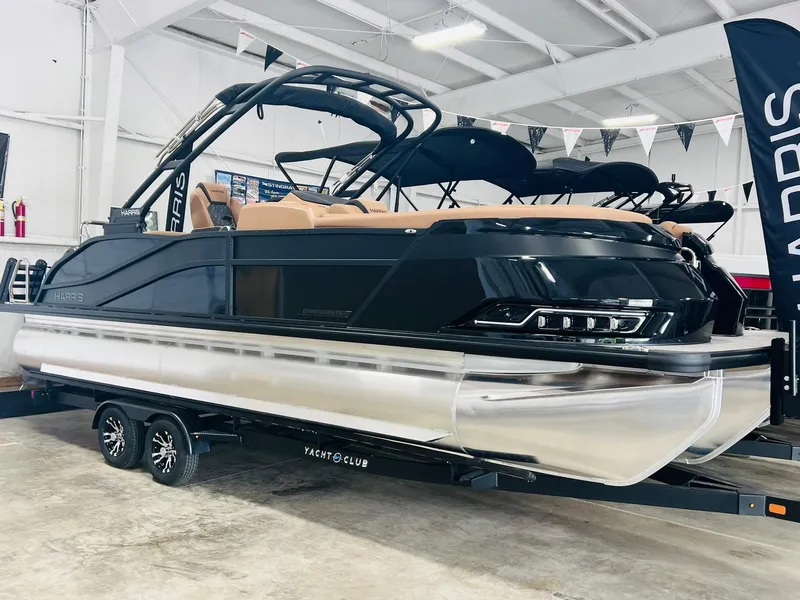 The Image of 2025 Harris Grand Mariner 230 pontoon boat in showroom, sleek black design on trailer. - 0
