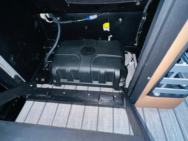 Slide: The Image of Battery compartment of 2025 Harris Grand Mariner 230 boat, featuring secure wiring and components. - 19