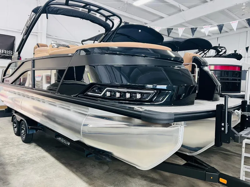 Slide: The Image of 2025 Harris Grand Mariner 230 pontoon boat in showroom, sleek black design. - 2