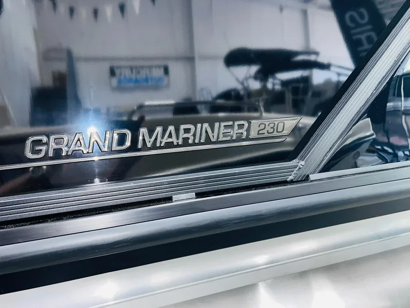 Slide: The Image of Close-up of 2025 Harris Grand Mariner 230 logo on a sleek boat surface. - 21