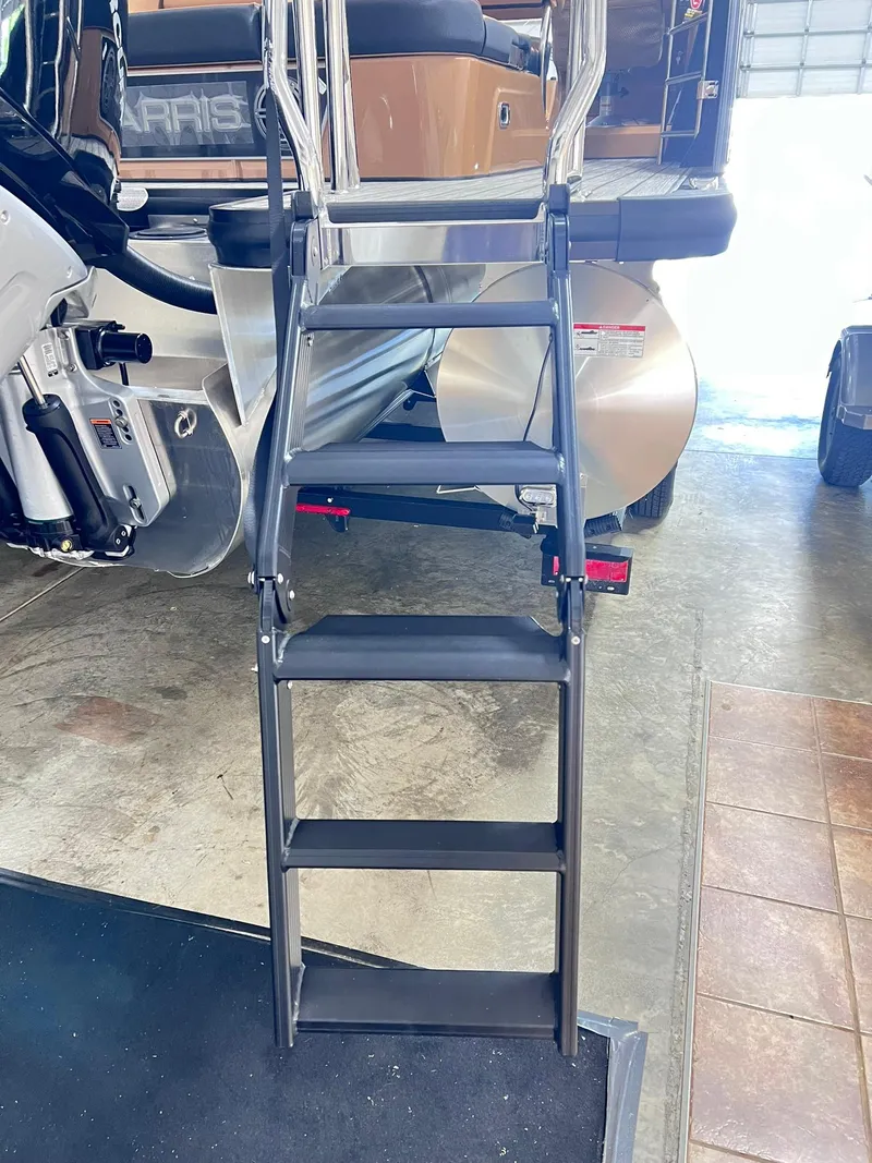 Slide: The Image of Ladder on 2025 Harris Grand Mariner 230 boat in a garage setting. - 25