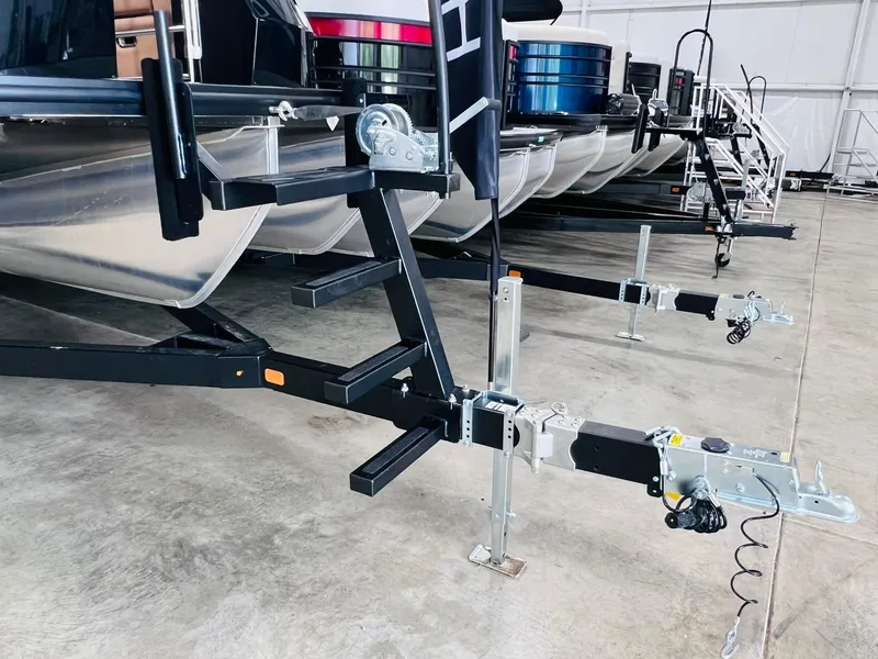 Slide: The Image of 2025 Harris Grand Mariner 230 boat trailers in a showroom. - 31