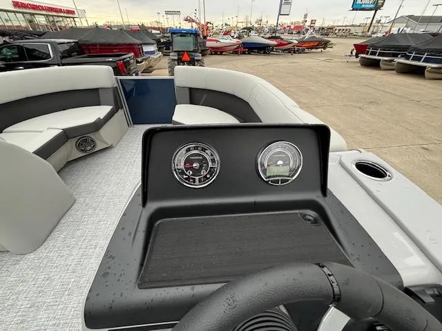 Slide: The Image of 2024 Harris Cruiser 210 CWDH boat dashboard with gauges and seating area. - 19