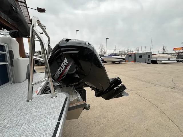 Slide: The Image of 2024 Harris Cruiser 210 CWDH with Mercury outboard motor in a boat dealership. - 3