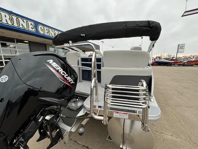 Slide: The Image of 2024 Harris Cruiser 210 CWDH pontoon boat with Mercury outboard motor at a marine center. - 5