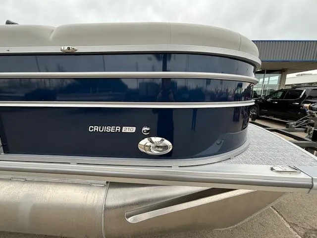 Slide: The Image of 2024 Harris Cruiser 210 CWDH pontoon boat, side view, blue and white exterior. - 6
