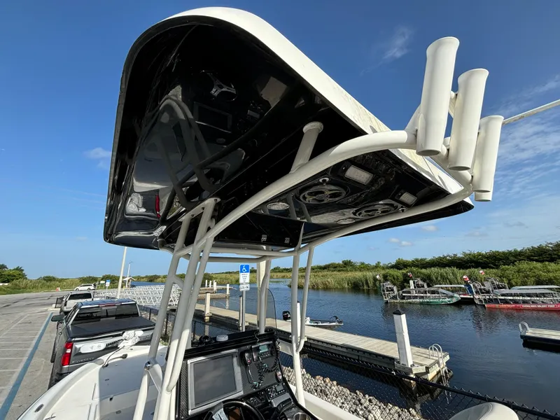 Slide: The Image of 2014 ShearWater 25LTZ boat with T-top and electronics at a dockside parking area. - 10
