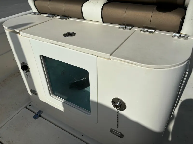 Slide: The Image of 2014 ShearWater 25LTZ boat storage compartment with cushioned seat. - 12