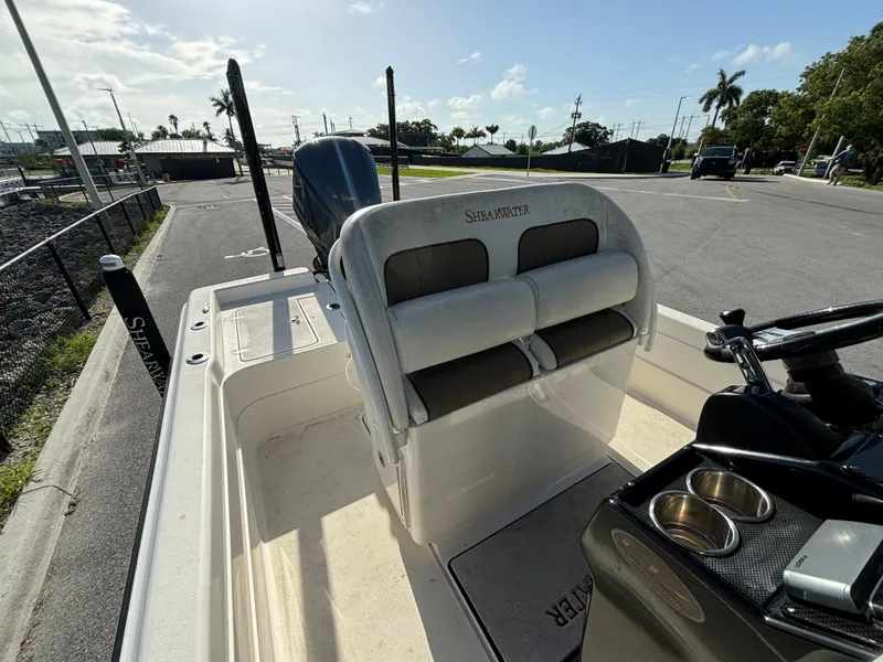 Slide: The Image of 2014 ShearWater 25LTZ boat interior with seating and console, parked on a sunny day. - 13
