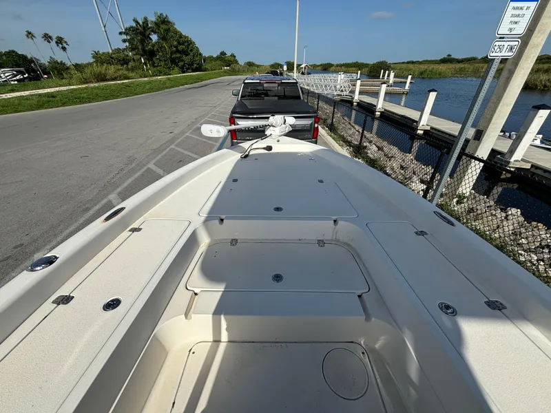Slide: The Image of 2014 ShearWater 25LTZ boat on trailer near waterfront, clear sky, and greenery. - 15