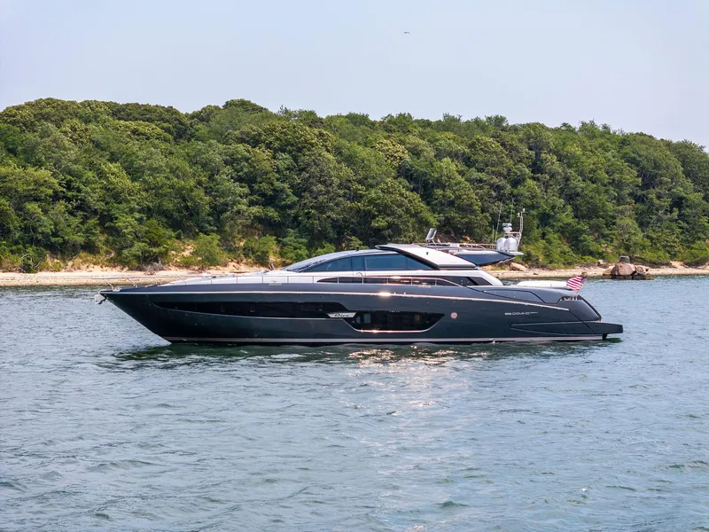 Slide: The Image of 2016 Riva 88' Domino Super yacht cruising near a forested shoreline. - 4