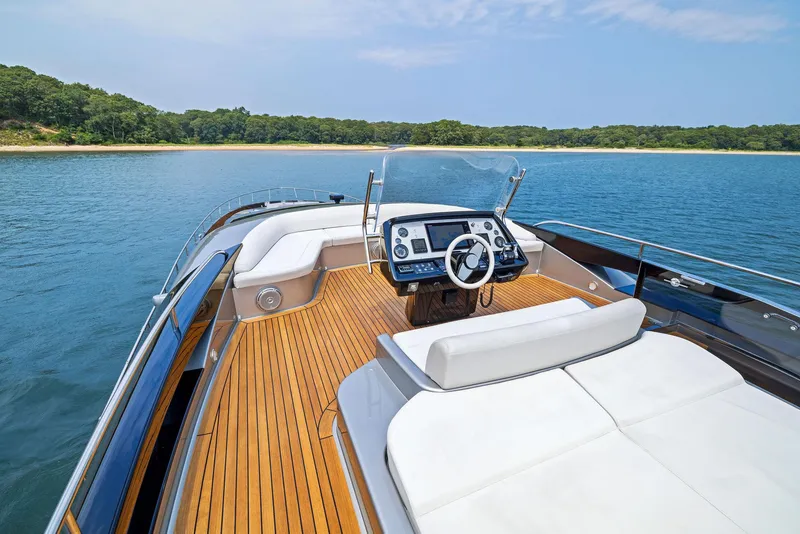 Slide: The Image of Riva 88' Domino Super 2016 yacht with luxurious deck and helm, anchored near a scenic shoreline. - 16