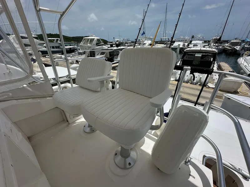 Slide: The Image of 2005 Luhrs 38 Convertible yacht with white captain chairs at marina. - 11