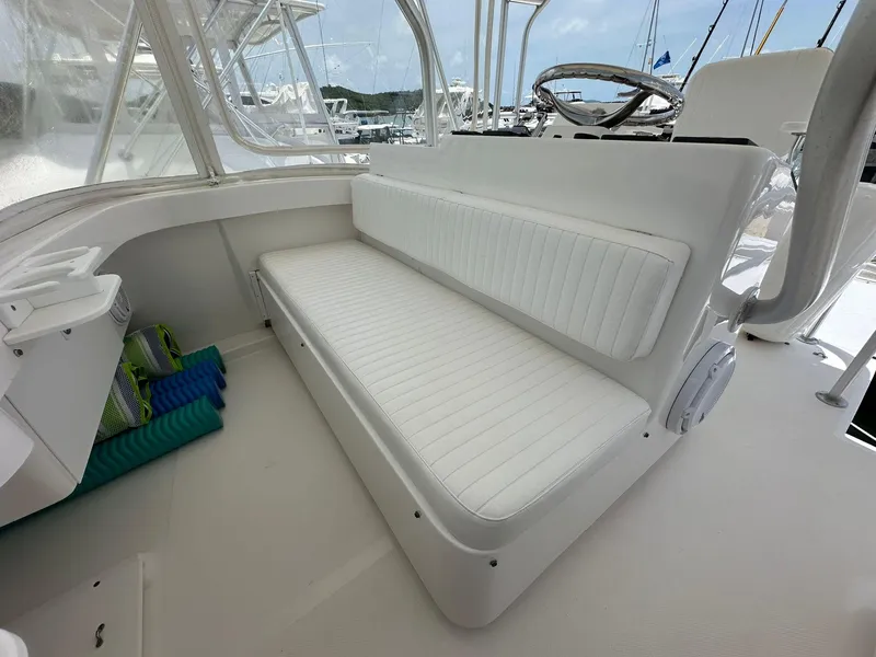 Slide: The Image of 2005 Luhrs 38 Convertible boat interior with white cushioned seating and helm. - 12
