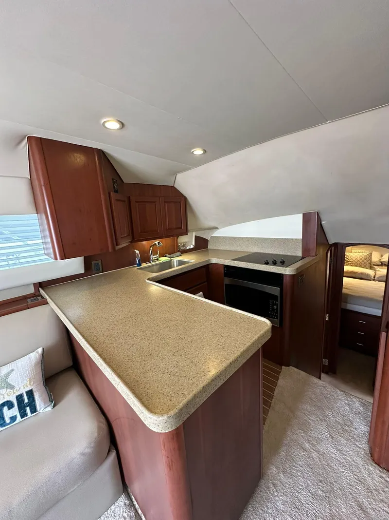 Slide: The Image of 2005 Luhrs 38 Convertible yacht interior with modern kitchen and cozy seating area. - 4