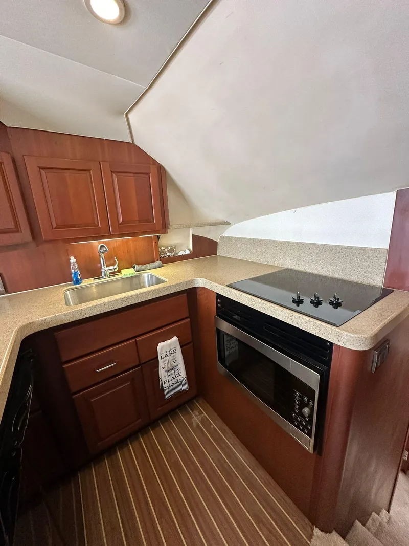 Slide: The Image of 2005 Luhrs 38 Convertible yacht kitchen with wood cabinetry and modern appliances. - 5