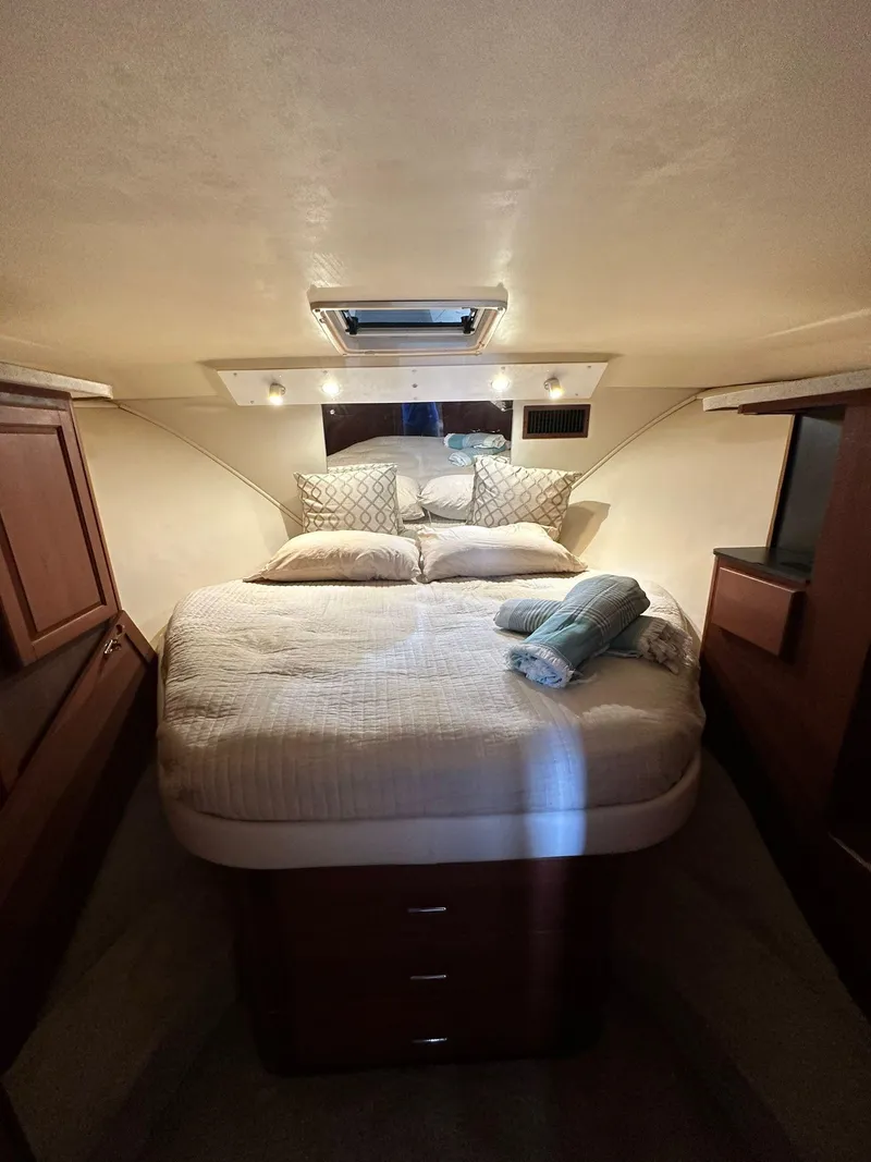 Slide: The Image of 2005 Luhrs 38 Convertible cabin with cozy bed and wooden cabinetry. - 7