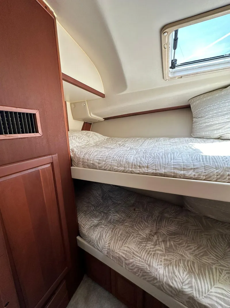 Slide: The Image of 2005 Luhrs 38 Convertible cabin with bunk beds and wooden cabinetry. - 9