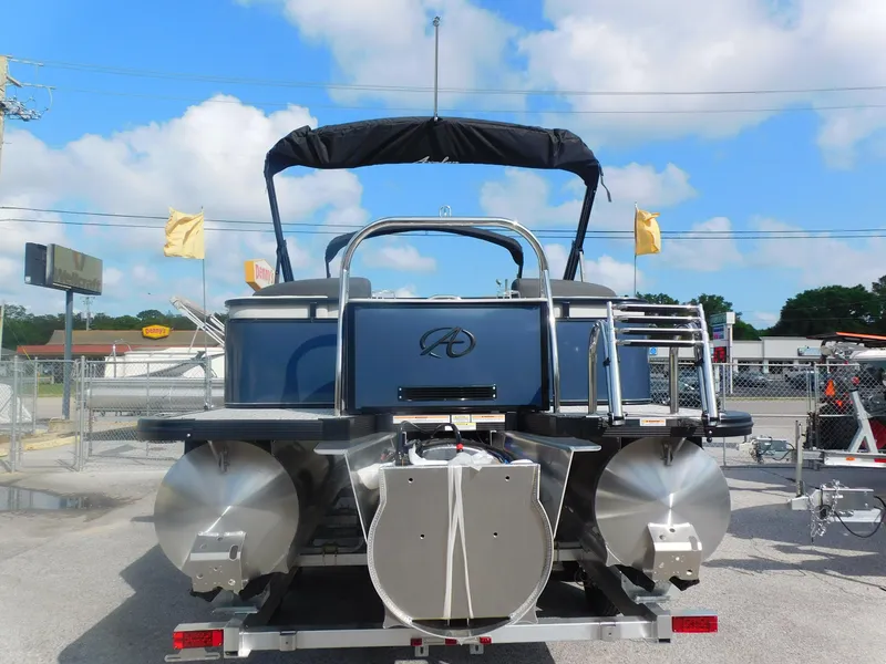 Slide: The Image of 2024 Avalon LSZ Quad Lounger pontoon boat, rear view, on trailer, under blue sky. - 6