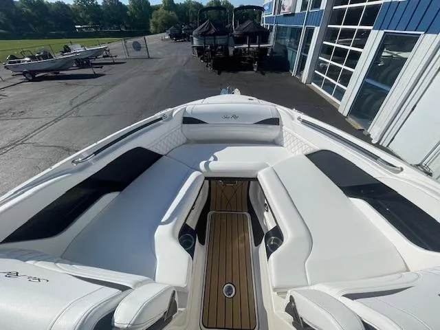 Slide: The Image of 2024 Sea Ray SLX 260 boat interior with white seating and wooden flooring. - 4