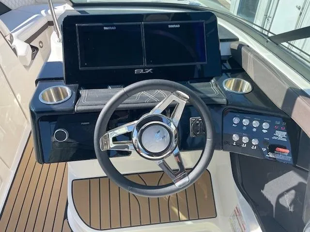 Slide: The Image of 2024 Sea Ray SLX 260 boat dashboard with steering wheel and dual Simrad displays. - 8