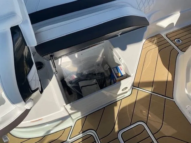 Slide: The Image of 2024 Sea Ray SLX 260 boat storage compartment with teak flooring. - 9