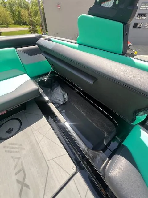 Slide: The Image of 2024 ATX Surf Boats 22 Type-S interior storage compartment with teal and black seating. - 20