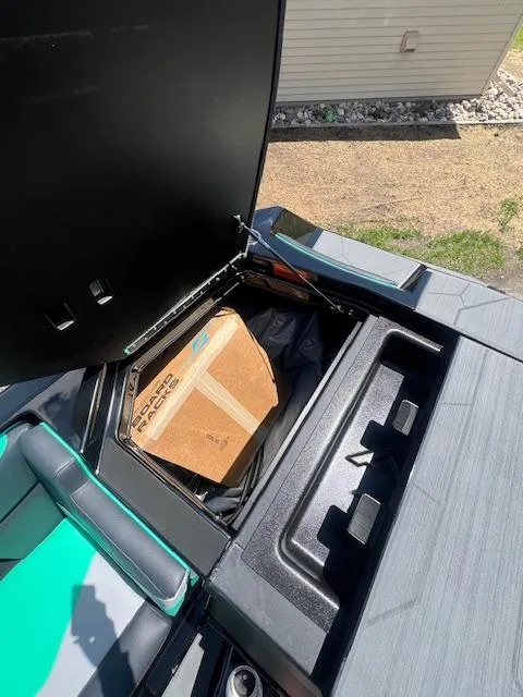 Slide: The Image of 2024 ATX Surf Boats 22 Type-S storage compartment with a cardboard box inside. - 24