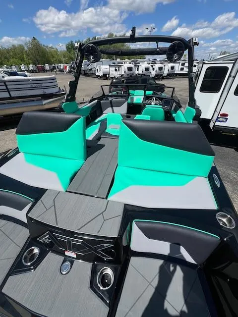 Slide: The Image of 2024 ATX Surf Boats 22 Type-S with teal and black interior, docked at a marina. - 25