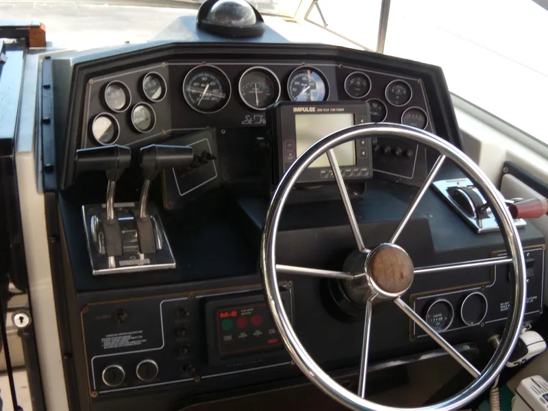 Slide: The Image of 1988 Wellcraft St. Tropez 3200 boat dashboard with steering wheel and control panel. - 10