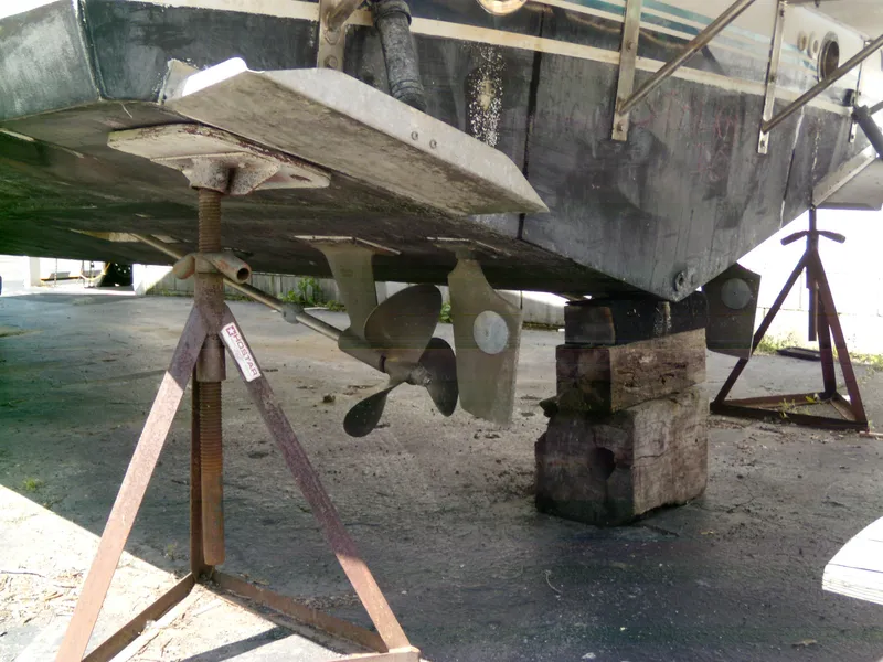 Slide: The Image of 1988 Wellcraft St. Tropez 3200 boat on dry dock, showing propeller and supports. - 4