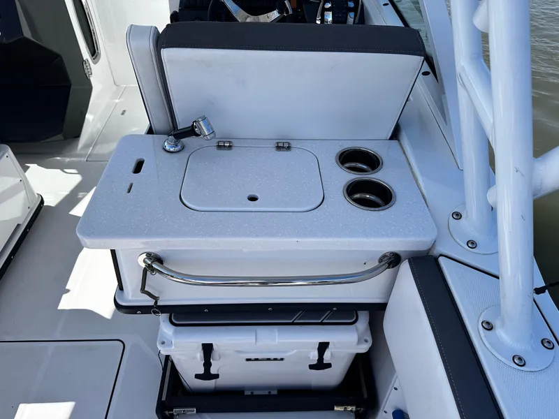 Slide: The Image of 2021 Blackfin 252 DC boat interior with sink, cup holders, and cooler storage. - 26