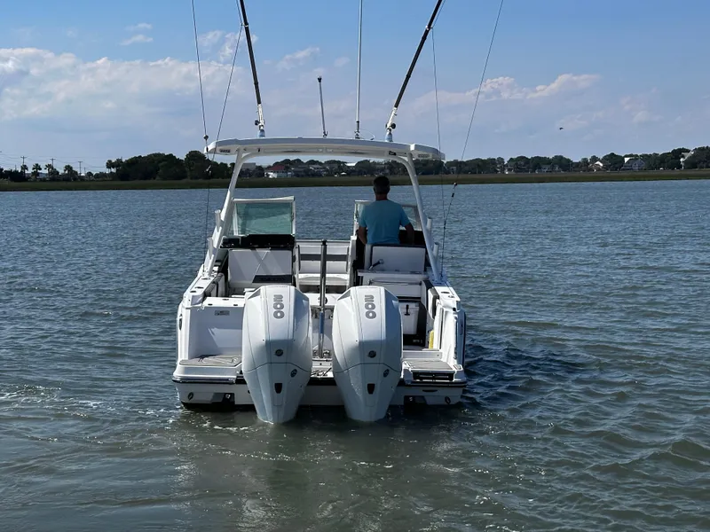 Slide: The Image of 2021 Blackfin 252 DC boat with dual outboard engines cruising on calm water. - 4