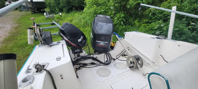 Slide: The Image of 1996 Mako 22 Center Console boat with dual outboard motors, parked on grass. - 13