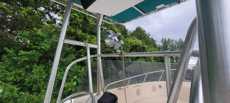 Slide: The Image of 1996 Mako 22 Center Console boat with canopy, surrounded by lush greenery. - 14