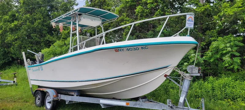Slide: The Image of 1996 Mako 22 Center Console boat on trailer, surrounded by greenery. - 2