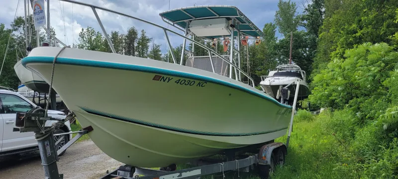Slide: The Image of 1996 Mako 22 Center Console boat on trailer, surrounded by greenery and other boats. - 3