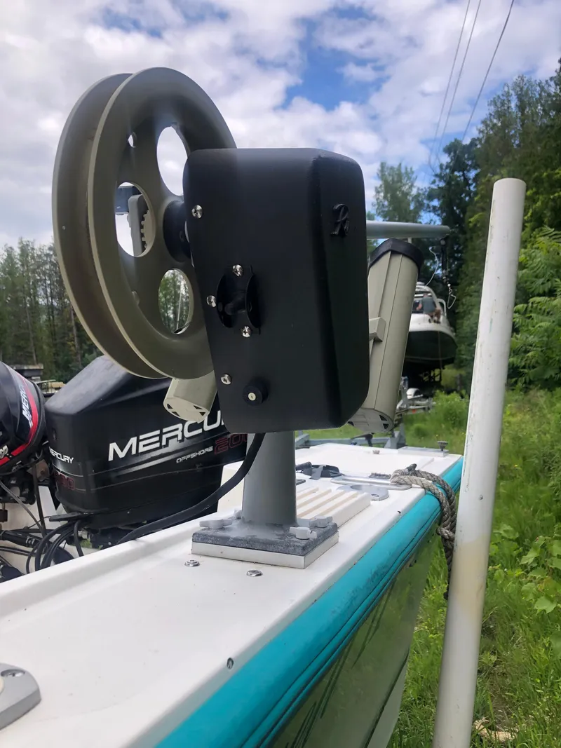 Slide: The Image of 1996 Mako 22 Center Console boat with fishing reel, outdoors, cloudy sky, and greenery. - 30