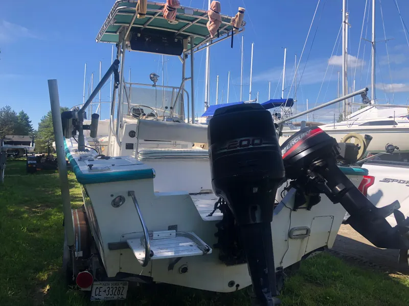 Slide: The Image of 1996 Mako 22 Center Console boat with dual outboard motors, docked on grass. - 9