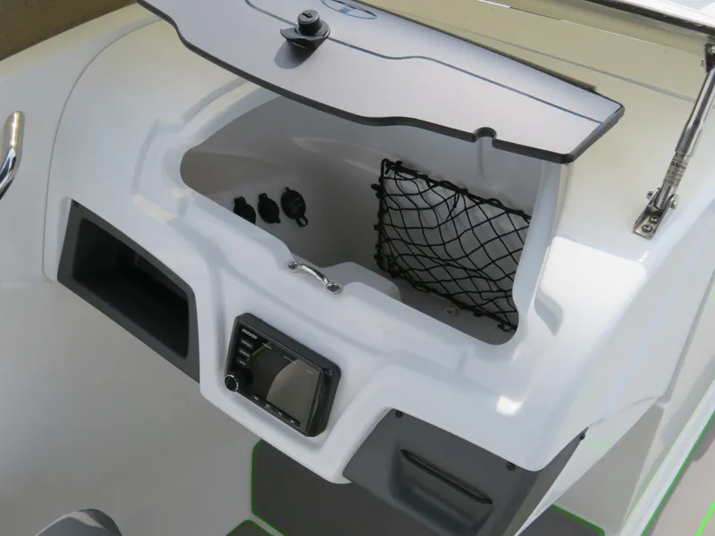 Slide: The Image of 2022 Tahoe 210 S Limited boat dashboard with storage compartment and net. - 13