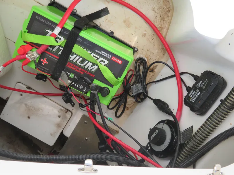 Slide: The Image of 2022 Tahoe 210 S Limited boat battery compartment with lithium battery and wiring. - 21