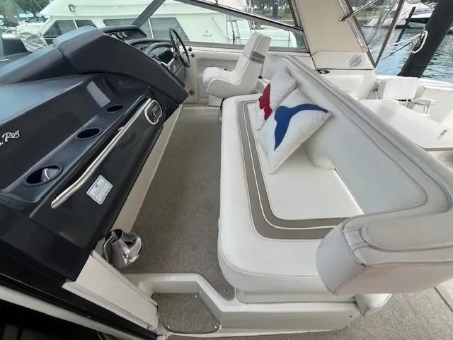 Slide: The Image of 1992 Sea Ray Sundancer interior with white seating and nautical-themed pillows. - 11